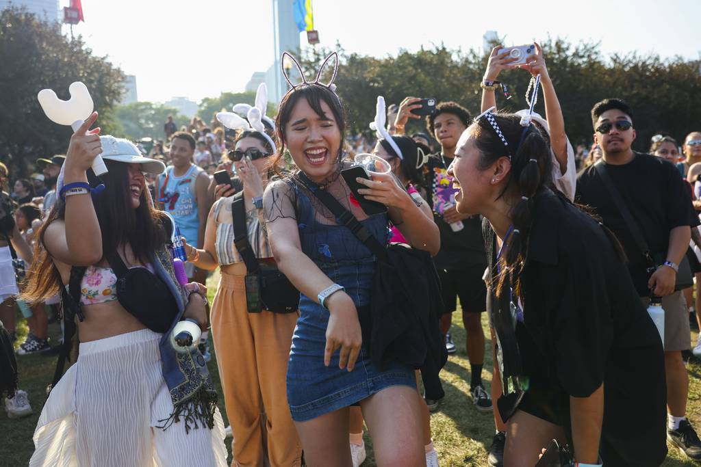 Linda Le of Oakland, California, from left, Brittany Lanham of Los Angeles and Abby Comes of Los Angeles dance as they perform NewJeans at Lollapalooza on August 3, 2023.  