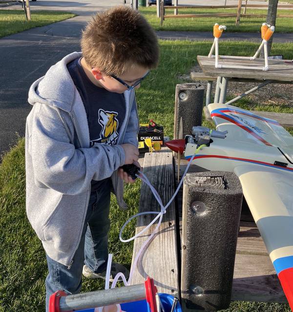 Brayden Douglas refuels a model airplane during a recent visit to the Tinley Creek Remote Controlled Flight Club's grounds in Matteson.  The 11-year-old player is the youngest member of the club.
