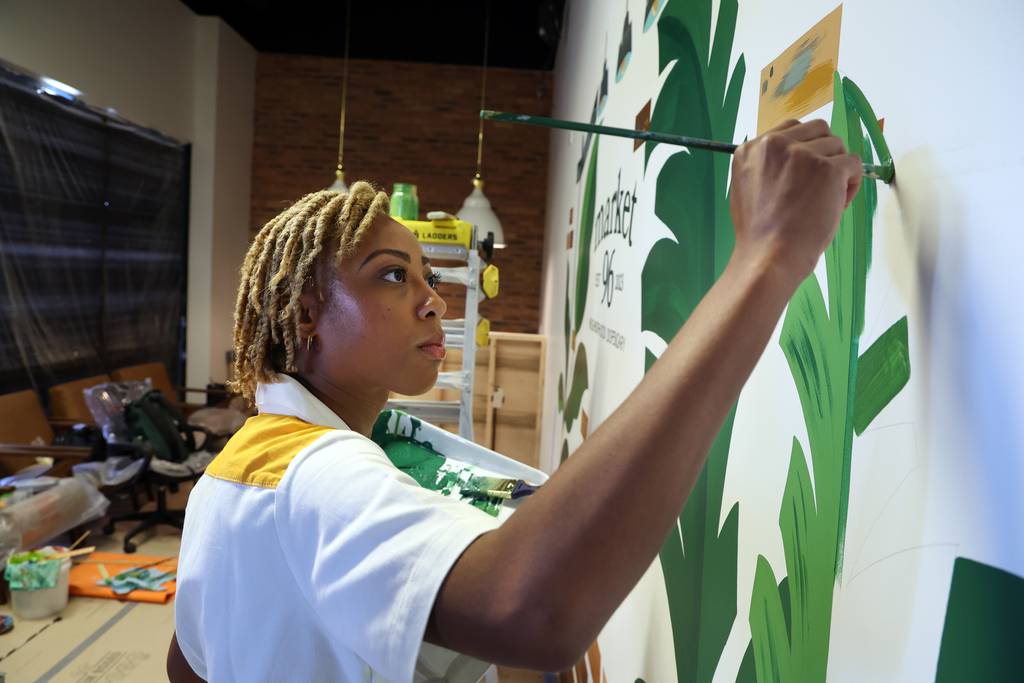 Artist Janel Young works on the site of the final mural of a marijuana dispensary to open in Oswego on July 20, 2023.  
