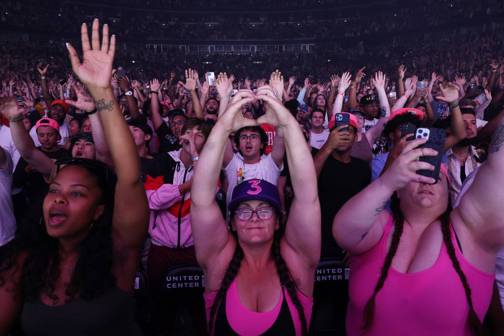 Concert attendees raise their hands as Chance the Rapper performs at United Center in Chicago on August 19, 2023. 
