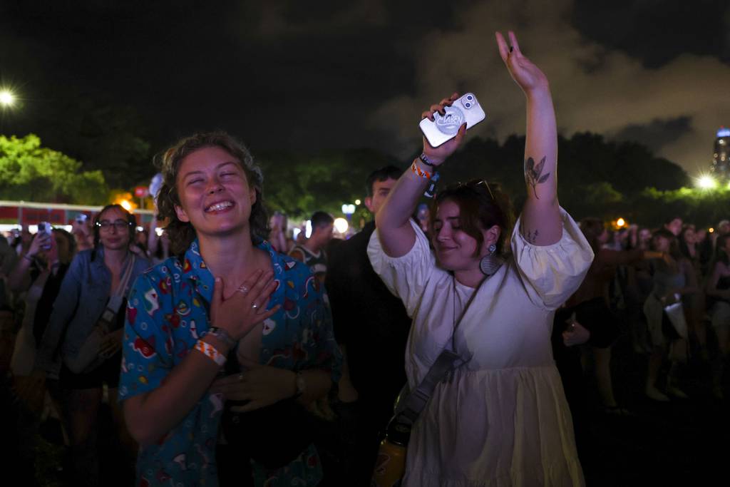 Molly Thornton, left, and Ronee Goldman dancing with Lana Del Rey performing on the Bud Light stage in Lollapalooza on August 6, 2023.  