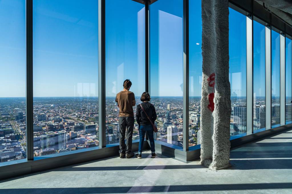 Visitors take in the view from the top floor of the Bank of America tower, which has since been completed, during the Open House Chicago 2021 presented by the Chicago Architecture Center.