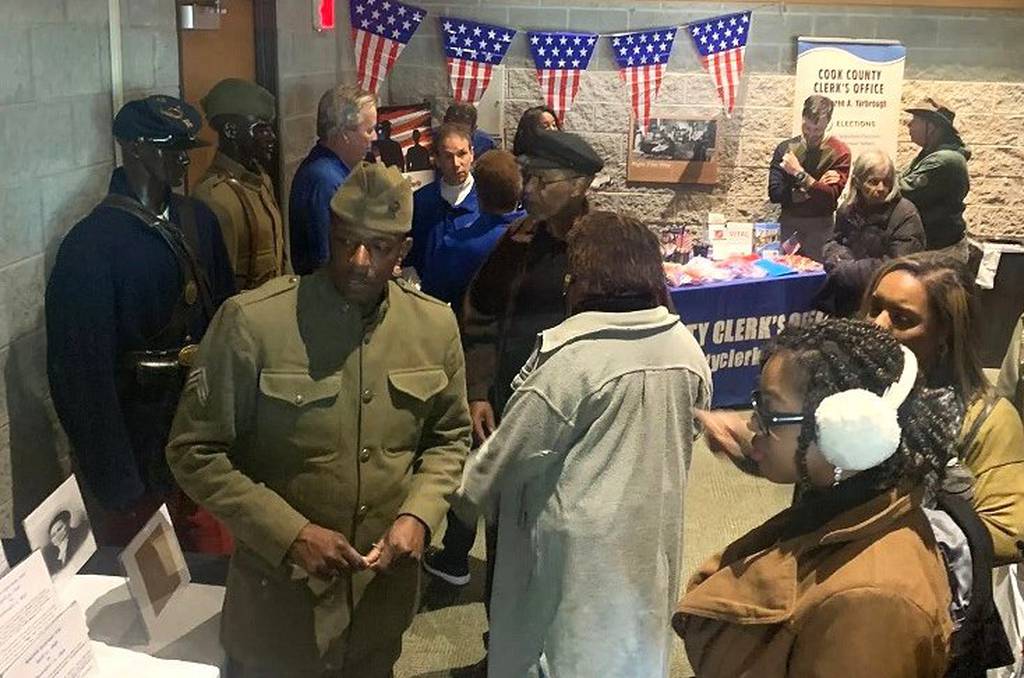 Dressed as a WWII soldier, Luther Johnson speaks to visitors at the Traveling History exhibit during the 2022 Veterans Day event at Brookfield Zoo.  Johnson prepares to transform the oldest house in Will County into the county's first museum of African American history.