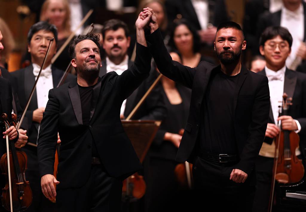 Guest conductor James Gaffigan, left, and pianist Conrad Tao take a bow in front of the Chicago Symphony Orchestra at the Symphony Center on Oct. 19, 2023.  