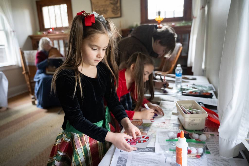 Valparaiso resident Annalia Gorgei, 6, paints candy canes during a traditional holiday celebration at the historic Chellberg House in Indiana Dunes National Park on Saturday, Dec. 16, 2023.  (Kyle Telechan for Post-Tribune)