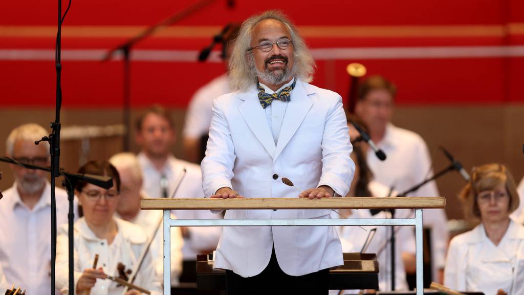 Conductor Carlos Kalmar receives applause from the crowd at the Grant Park Music Festival season opener at Millennium Park in Chicago on June 14, 2023.