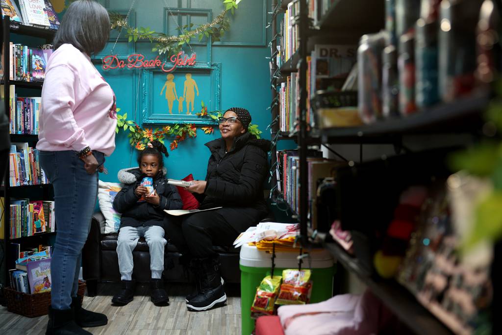 Lanyha Pascascio, 7, and her grandmother, Lesa Beckom, on Jan. 20, 2024, at Da Book Joint, 330 E. 51st St. in Chicago.  Talking to Verlean Singletary (left) at.  Singletary had planned to close the business at the end of 2023 but will keep it going. 
