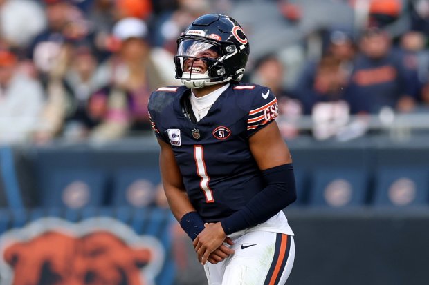 Chicago Bears quarterback Justin Fields (1) holds his ankle as he walks off the field during the third quarter of a game against the Minnesota Vikings on October 15, 2023 at Soldier Field in Chicago.  (Chris Sweda/Chicago Tribune):