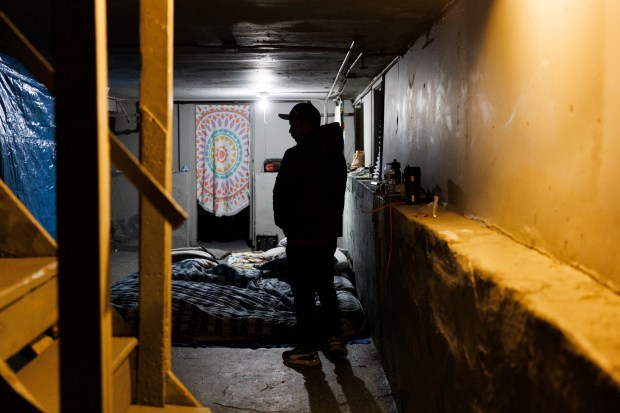 Francisco Hernandez, a 31-year-old Venezuelan, stands in the basement of a home shared by several immigrant families in Chicago's Roseland neighborhood on Jan. 30, 2024, before taking his children to school.  The owner of the house is the property manager.  Chris Amatore said Chicago houses more than 400 immigrants in apartments and houses.  (Armando L. Sanchez/Chicago Tribune)