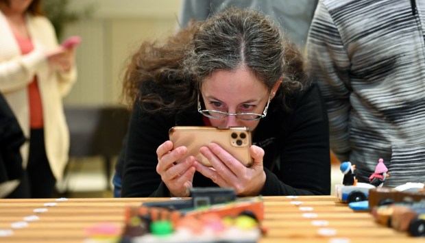 Allyson Jacobson of Winnetka takes a photo to remember the car built by her son, Daniel Albrecht, 10, a fifth-grader, at the Cub Scout Pack 18 Pinewood Derby at Winnetka Presbyterian Church (1255 Willow Road) on Jan. 31, 2024, in Winnetka .