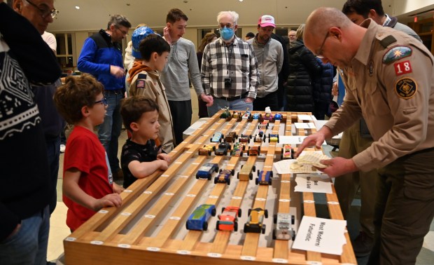 Far right, Cubmaster of Cub Scout Pack 18, Khalid Ghantous of Winnetka, checks the cars before the race in the Cub Scout Pack 18 Pinewood Derby at Winnetka Presbyterian Church (1255 Willow Road) on Jan. 31, 2024 in Winnetka.