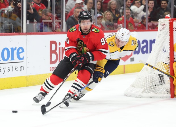 Chicago Blackhawks center Tyler Johnson (90) and Nashville Predators center Gustav Nyquist (14) skate to the puck during the first period at the United Center on Dec. 5, 2023.
