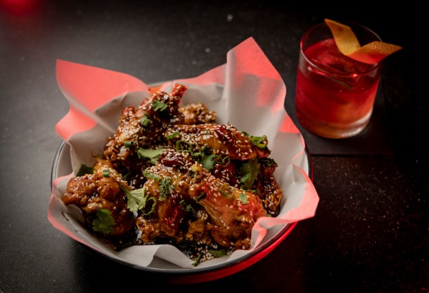 General Jones' chicken wings and Cheating Death cocktail at Nine Bar on February 13, 2023.  (Brian Cassella/Chicago Tribune)