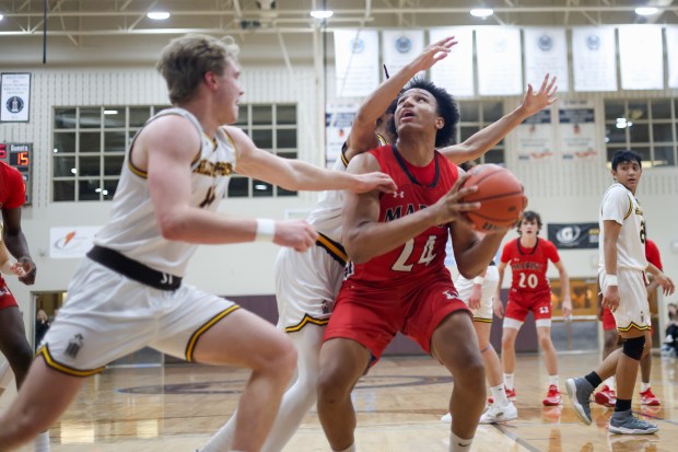 Marist's Achilles Anderson (24) pumps a defender during a game against Joliet Catholic Academy on Thursday, Feb. 8, 2024, in Joliet.  (Troy Stolt for Daily Southtown)