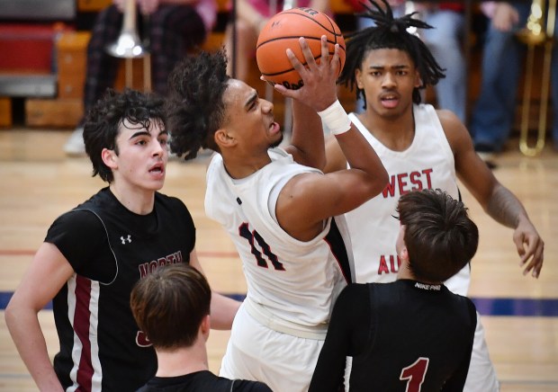 West Aurora's Jordan Brooks (11) drives to the basket in the crowd during a game against Plainfield North on Friday, Feb. 9, 2024, in Aurora.(Jon Cunningham for The Beacon-News)