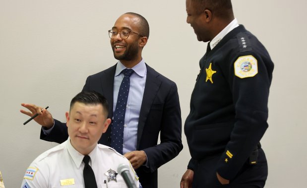 New Chicago Police Board chairman Kyle Cooper (center) and police Chief Larry Snelling (right) meet before the monthly Chicago Police Board meeting on Dec. 21, 2023.  (Chris Sweda/Chicago Tribune)