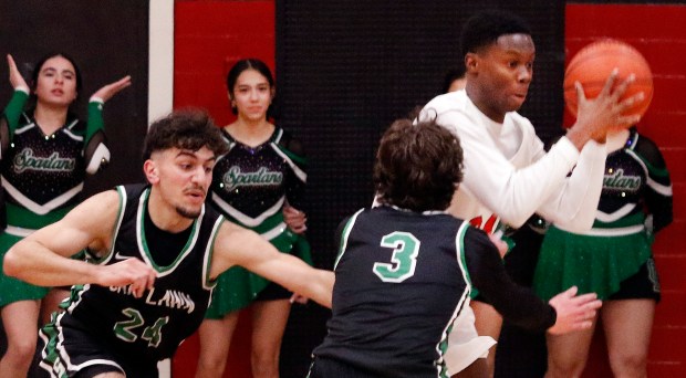 Oak Lawn's Omar Saleh (left) and Jack Dempsey (center) chase after a loose ball as Eisenhower's Ola Solomon (right) during a basketball game on Tuesday, Feb. 13, 2024, in Blue Island.  (John Smierciak/Daily Southtown)