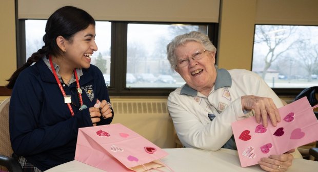 Anne McAuley junior Julissa Gonzalez and Mercy Circle resident Betty Jean Bischel laugh as they decorate candy bags to be donated to Pat's Pantry.  (Circle of Mercy)