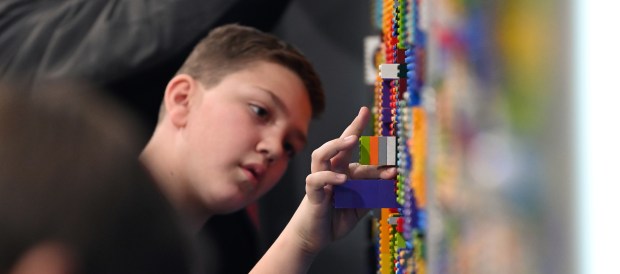 Alexs Djurdjevic, 11, a fifth-grader from Hoffman Estates, moves LEGO bricks on a graffiti art wall at Brick Fest Live at the Lake County Fairgrounds and Events Center on Feb. 17, 2024.  Karie Angell Luc of the Lake County News-Sun.