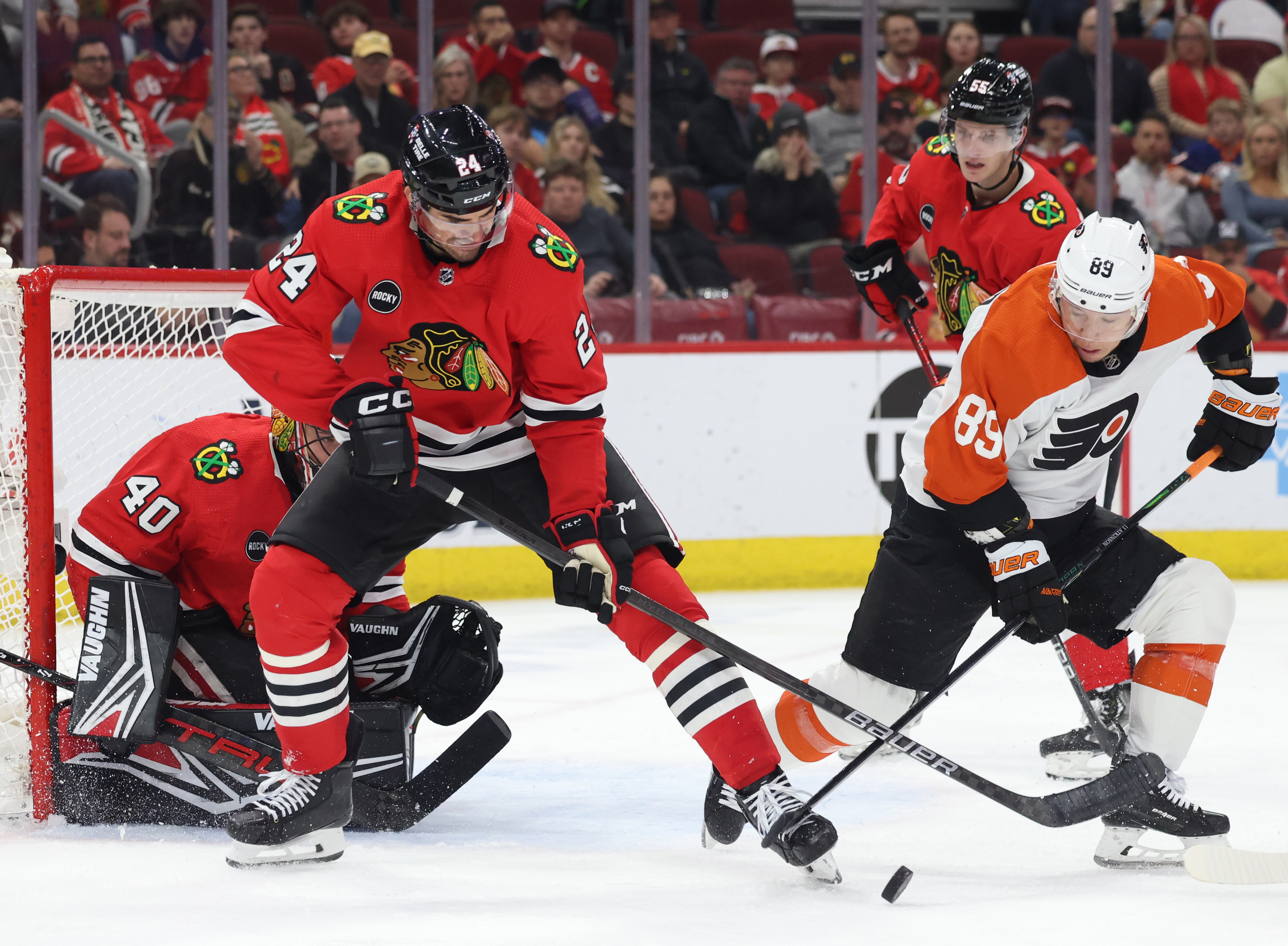 Blackhawks defenseman Jaycob Megna (24) and Flyers right winger Cam Atkinson (89) stick together during the second period at the United Center in Chicago on Feb. 21, 2024.  (John J. Kim/Chicago Tribune)