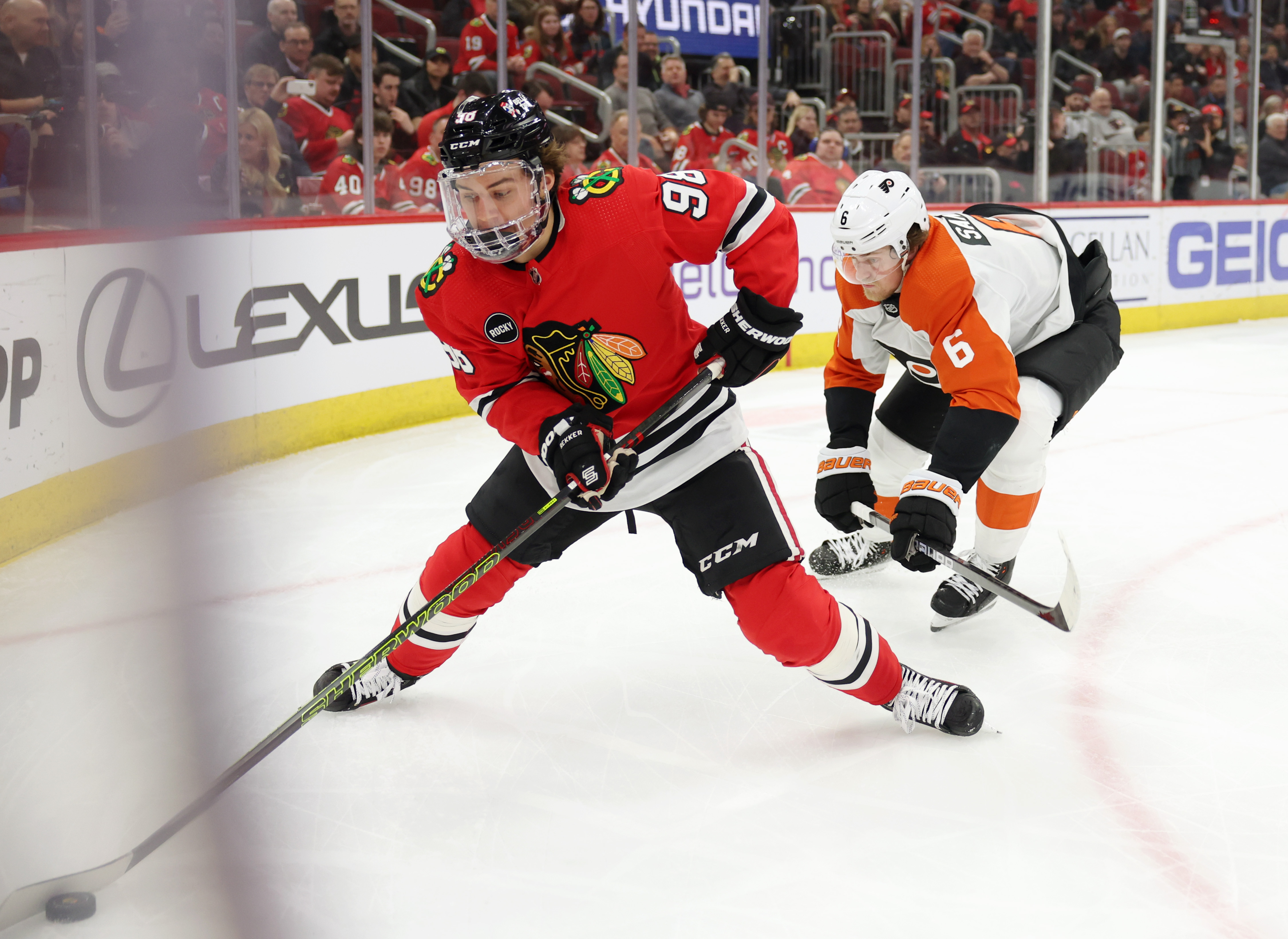 Blackhawks center Connor Bedard (98) handles the puck chased by Flyers defenseman Travis Sanheim (6) in the first period at the United Center in Chicago on Feb. 21, 2024.  (John J. Kim/Chicago Tribune)