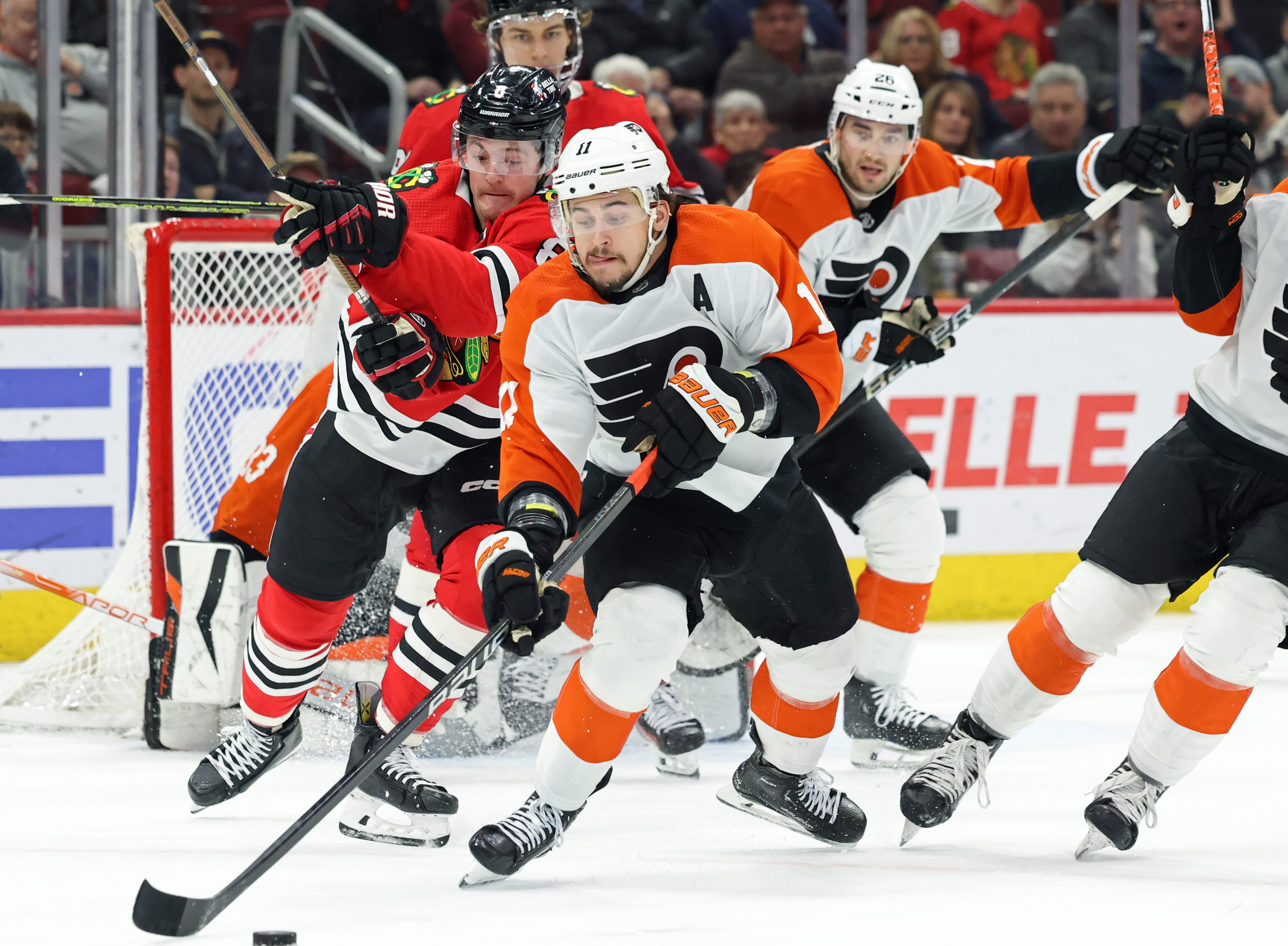 Flyers right winger Travis Konecny ​​(11) walks away with the puck as Blackhawks center Ryan Donato (8) chases the ball in the third period at the United Center in Chicago on February 21, 2024.  (John J. Kim/Chicago Tribune)