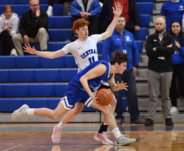 Marmion's Evan Stumm passes Burlington Central's Patrick Shell (11) during the Class 3A Marmion Regional semifinal game in Aurora on Wednesday, Feb. 21, 2024.(Jon Cunningham for The Beacon-News)