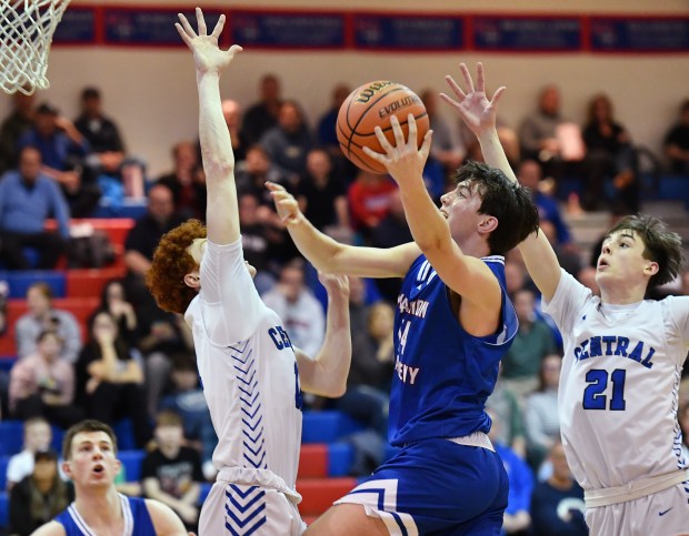 Marmion's Evan Stumm drives to the basket between Burlington Central defensemen Patrick Shell and Patrick Magan (21) during the Class 3A Marmion Regional semifinal game in Aurora on Wednesday, Feb. 21, 2024.(Jon Cunningham for The Beacon-News)
