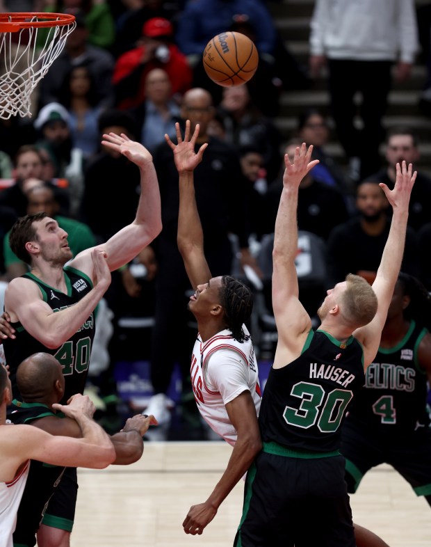 Bulls forward Julian Phillips takes a shot between Celtics center Luke Kornet (40) and forward Sam Hauser at the United Center on Feb. 22, 2024. 