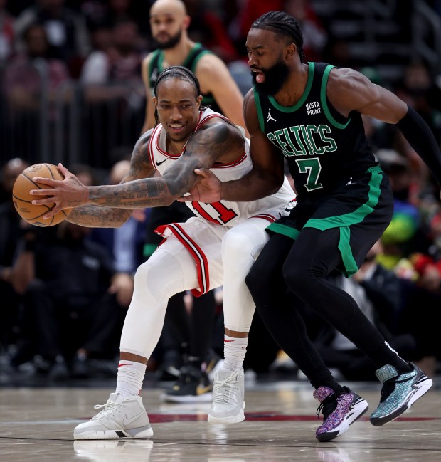 Bulls forward DeMar DeRozan (left) catches a loose ball in front of Celtics guard Jaylen Brown at the United Center on February 22, 2024. 