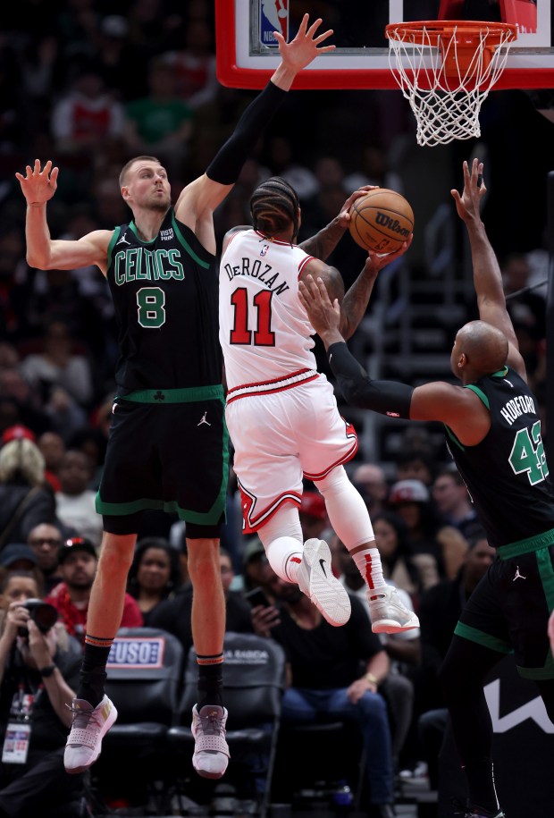 Bulls forward DeMar DeRozan (11) tries to pass Celtics centers Kristaps Porzingis (8) and Al Horford at the United Center on February 22, 2024. 