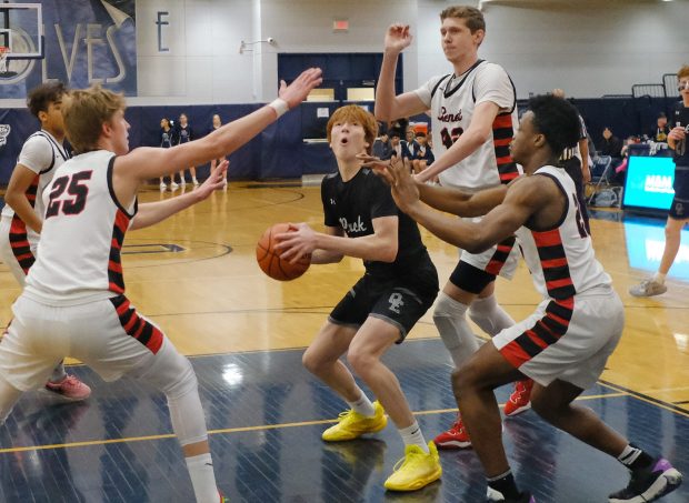 Oswego East's Noah Mason looks at the basket as the Benet defense approaches during the Class 4A Oswego East Regional final game in Oswego on Friday, Feb. 23, 2024.(Jon Cunningham for Naperville Sun)