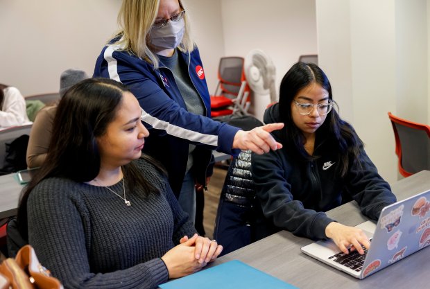 Ashton Spatz (center), a financial aid counselor at the University of Illinois at Chicago, assists Jessena Sanchez, left, and her daughter Leslie Delve, a sophomore at UIC, during a FAFSA workshop at the Student Finance Center on Feb. 23, 2024 .  Assistance Bureau.  (Vincent Alban/Chicago Tribune)