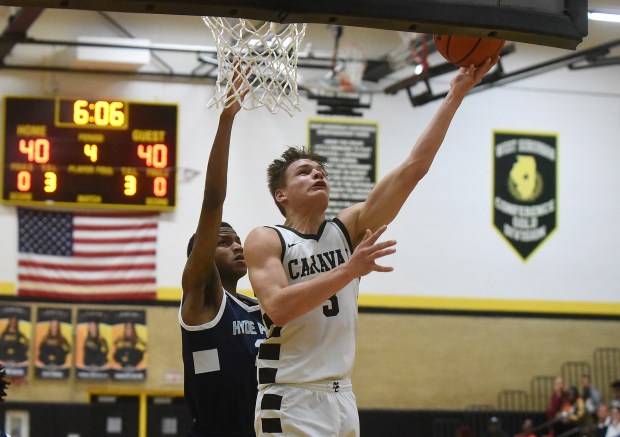 Mount Carmel's Grant Best (3) makes a basket against Hyde Park's Marquise Merritt (2) during the Class 3A Hinsdale South Regional semifinals on Tuesday, February 27, 2024 in Darien, IL.  (Steve Johnston/Daily Southtown)