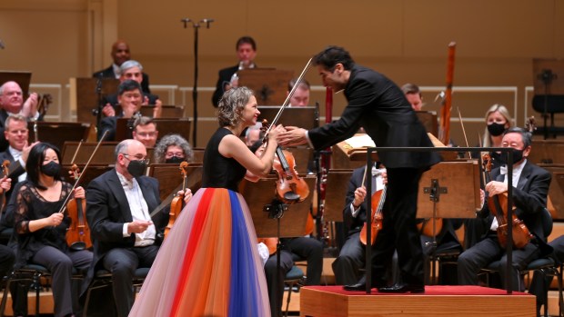 Chicago Symphony Orchestra guest artist Hilary Hahn shakes hands with conductor Andrés Orozco-Estrada during a concert at the Symphony Center on December 9, 2021.  Orozco-Estrada will open the CSO's next season with a program that includes Hahn.  (Victor Hilitski of the Chicago Tribune)
