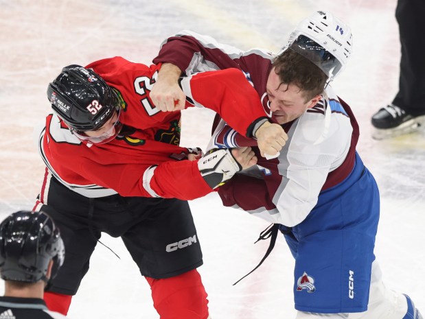 Blackhawks center Reese Johnson (52) and Avalanche right wing Chris Wagner fight during the second period at the United Center on Feb. 29, 2024.  (John J. Kim/Chicago Tribune)