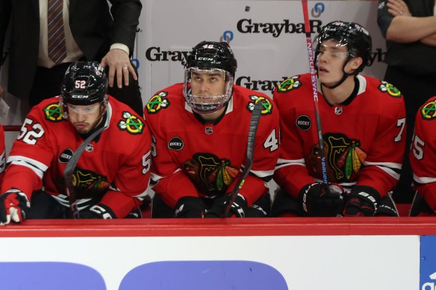 Blackhawks defenseman Louis Crevier (46) wears a full-face mask while sitting on the bench during the first period against the Avalanche at the United Center on Feb. 29, 2024.  (John J. Kim/Chicago Tribune)