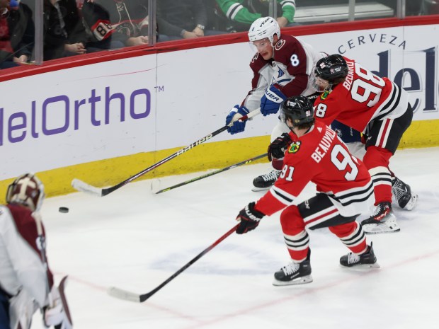 Blackhawks center Connor Bedard (98) reaches for the puck as Avalanche defenseman Cale Makar (8) passes the ball in the first period at the United Center on Feb. 29, 2024.  (John J. Kim/Chicago Tribune)