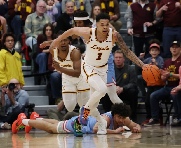 Dayton forward Nate Santos lies on the court during the first half at Gentile Arena on March 1, 2024, while Loyola guard Jayden Dawson (1) makes a steal and leaves the game.  (John J. Kim/Chicago Tribune)