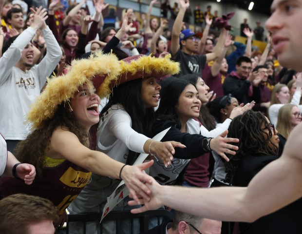 Wearing feathered cowboy hats, Loyola students Melisa Sulievic (left) and Nyah Moore celebrate a 77-72 victory over Dayton at Gentile Arena on March 1, 2024.  (John J. Kim/Chicago Tribune)