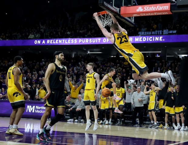Iowa forward Ben Krikke dunks in front of Northwestern guard Boo Buie during the second half at Welsh-Ryan Arena in Evanston on March 2, 2024.  (Chris Sweda/Chicago Tribune)
