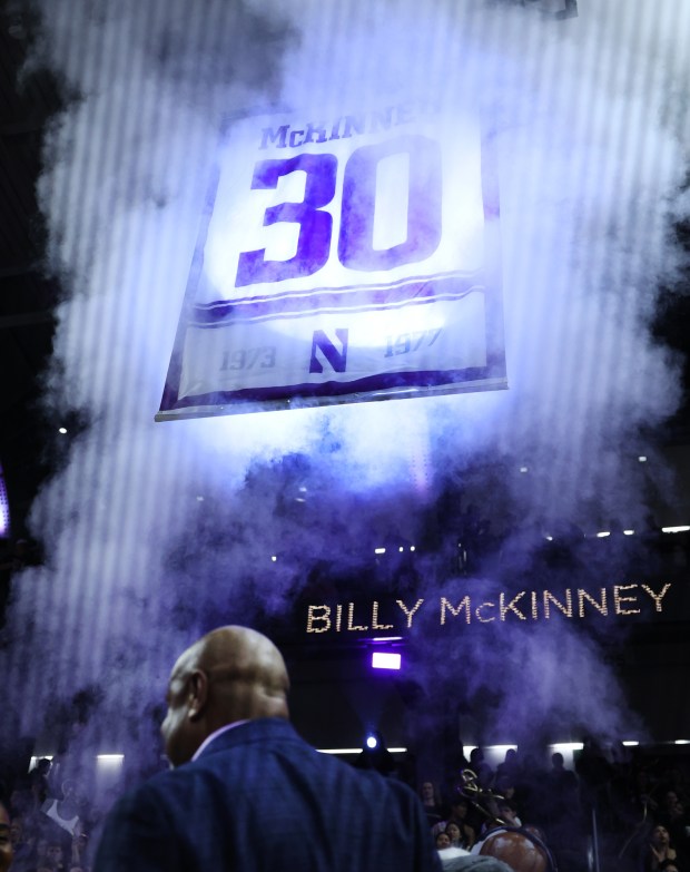 Former Northwestern player Billy McKinney stands on the floor as his No. 30 is raised during a ceremony during halftime of the game between Northwestern and Iowa at Welsh-Ryan Arena in Evanston on March 2, 2024.  (Chris Sweda/Chicago Tribune)