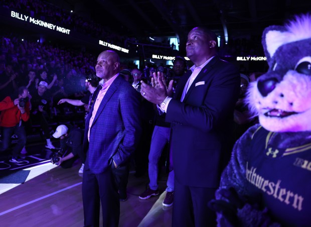 Former Northwestern star Billy McKinney (left) stands on the floor as his No. 30 is lifted to the rafters during the halftime ceremony at Welsh-Ryan Arena in Evanston on March 2, 2024.  (Chris Sweda/Chicago Tribune)