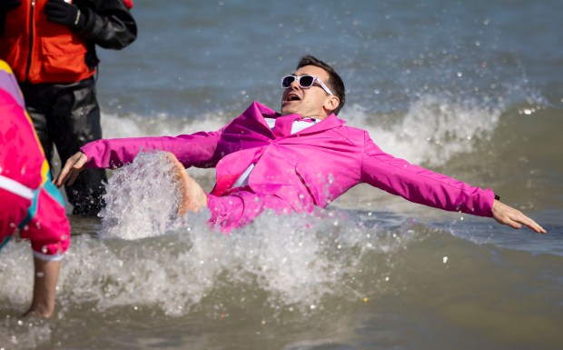 Costumed participants dive into Lake Michigan on a warm morning during the 24th Annual Chicago Polar Plunge at North Avenue Beach on Sunday, March 3, 2024.  (Brian Cassella/Chicago Tribune)