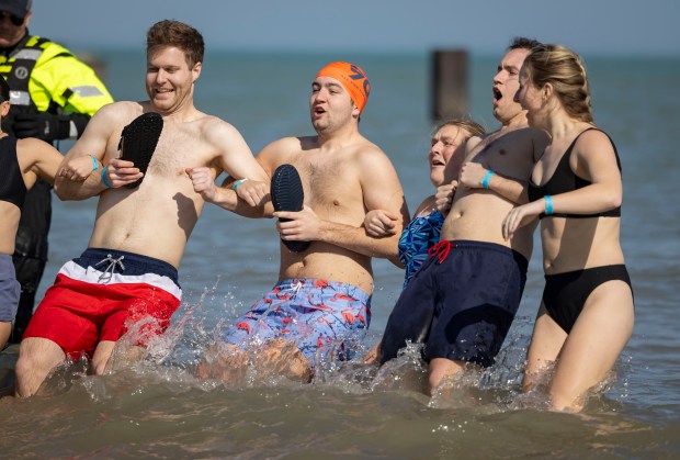 Participants dive into Lake Michigan on a warm morning during the 24th Annual Chicago Polar Plunge on Sunday, March 3, 2024, at North Avenue Beach.  (Brian Cassella/Chicago Tribune)