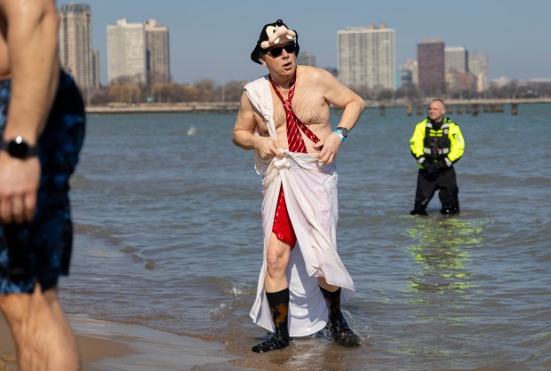Costumed participants dive into Lake Michigan on a warm morning during the 24th Annual Chicago Polar Plunge at North Avenue Beach on Sunday, March 3, 2024.  (Brian Cassella/Chicago Tribune)
