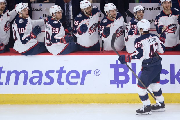 Columbus Blue Jackets' Alexandre Texier (42) celebrates with teammates on the bench after scoring a goal in the first period of an NHL hockey game against the Chicago Blackhawks on Saturday, March 2, 2024 in Chicago.  (AP Photo/Paul Beaty)