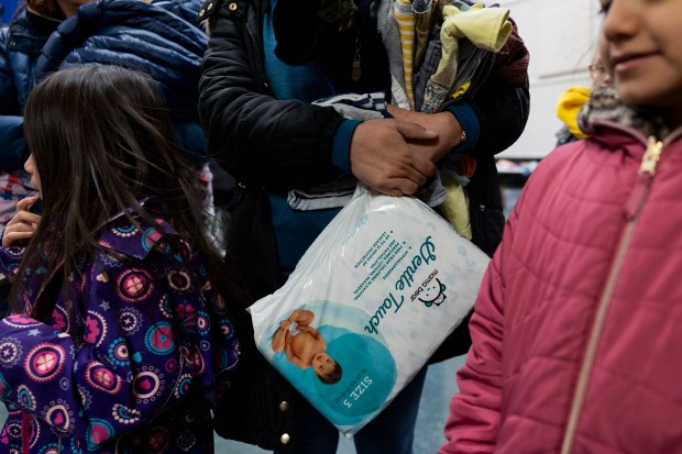 Any Sanchez holds a pack of diapers on February 24, 2024, at a supply drive called. "Free Gifts for Families" Hosted by Southwest Collective at Edwards Elementary School in Chicago.  (Vincent Alban/Chicago Tribune)