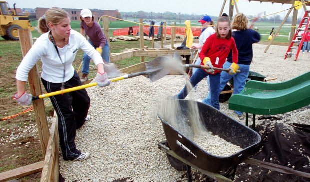 Volunteers load wheelbarrows with crushed stone as community members gather to build the Fort Frankfort playground at Sauk Trail and 80th Avenue in Frankfort on Oct. 16, 1999.  Nearly a quarter-century later, the playground will get a major update thanks to a $1.7 million state grant.  (John Smierciak/Chicago Tribune)
