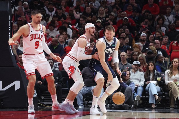 Bulls center Nikola Vucevic (9) watches Bulls guard Alex Caruso (6) defend against Mavericks guard Luka Doncic (77) at the United Center in Chicago on March 11, 2024.  (Terrence Antonio James/Chicago Tribune)